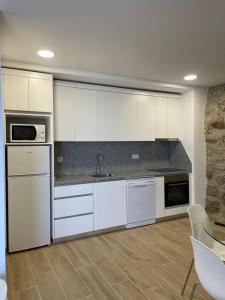 a kitchen with white cabinets and a counter top at Casa do capitão A casa ideal para férias no Gerês in Vieira do Minho