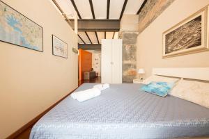 Loft Galata في جينوا: غرفة نوم عليها سرير وفوط