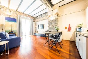 un soggiorno con divano blu e tavolo di Loft Galata a Genova