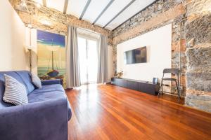 un soggiorno con divano blu e muro di mattoni di Loft Galata a Genova