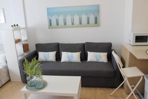 un soggiorno con divano grigio e cuscini di Paseo Maritimo a Málaga