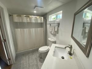 a white bathroom with a toilet and a sink at Royale Inn Motel in Whittier