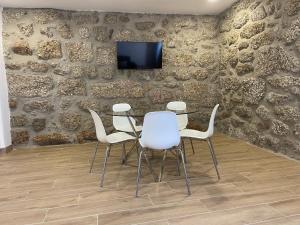 a conference room with a table and white chairs at Casa do capitão A casa ideal para férias no Gerês in Vieira do Minho