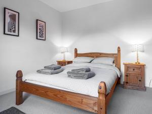 Stocksfield的住宿－The Cottage，一间卧室配有一张带毛巾的木床