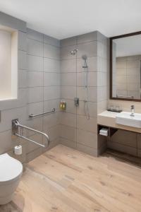 y baño con ducha, aseo y lavamanos. en Fairfield by Marriott Goa Benaulim, en Benaulim