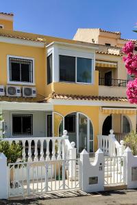 uma casa com uma cerca branca em frente em Villa del Sol em Gran Alacant