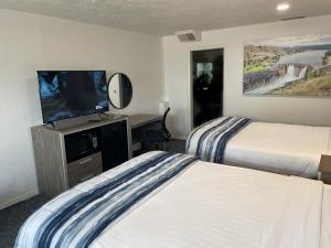 Habitación de hotel con 2 camas y TV de pantalla plana. en Americas Best Value Inn Polson en Polson