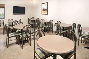 a dining room with tables and chairs and a tv at Super 8 by Wyndham Walla Walla in Walla Walla
