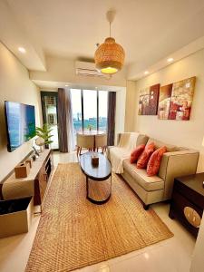 uma sala de estar com um sofá e uma mesa em Verdela Pollux Meisterstadt Batam apartement em Batam Center
