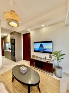 een woonkamer met een flatscreen-tv aan de muur bij Verdela Pollux Meisterstadt Batam apartement in Batam Center
