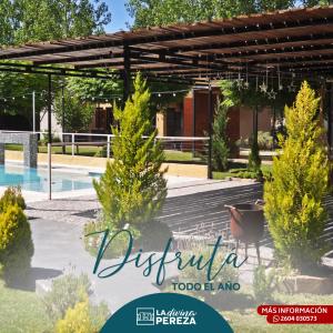 a garden with a pergola and a swimming pool at La Divina Pereza in San Rafael