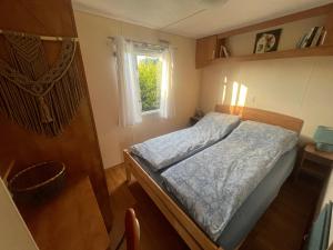 mała sypialnia z łóżkiem i oknem w obiekcie Mandala Mielno Camping w mieście Mielno