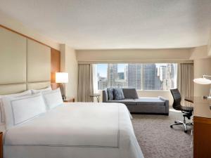 um grande quarto de hotel com uma cama grande e um sofá em Swissotel Chicago em Chicago