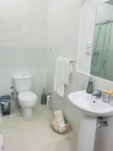 a white bathroom with a toilet and a sink at Perfect City Center in Praia