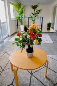 un jarrón lleno de flores sentado en una mesa en Hotel Hviezda, en Diakovce