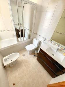 a white bathroom with a sink and a toilet at Las Marinas, apartamento muy amplio cerca de la playa in Benidorm