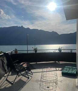 a patio with a chair and a view of the water at Superbe Appartement avec vue sur le Lac du Bourget in Tresserves