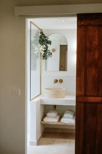 a bathroom with a sink and a mirror and towels at Wabi sabi lodge&spa in Turenne