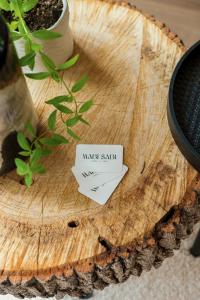 a sign on top of a wooden stump with a plant at Wabi sabi lodge&spa in Turenne