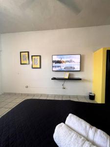 a living room with a flat screen tv on a wall at The Next Door Black and White Studio In Cabo in Cabo San Lucas