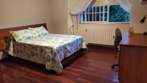 a bedroom with a bed and a window at Os piñeiros vacacional in Moaña