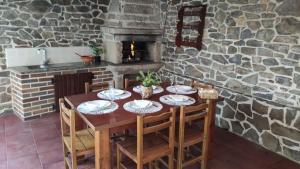 a table in a kitchen with a stone fireplace at Os piñeiros vacacional in Moaña