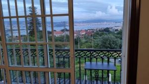 a window with a view of the city and water at Os piñeiros vacacional in Moaña