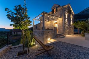 a house with a tree and a chair on a patio at Villa Le Adria - Private HotTub - Free Beach Parking in Kozica
