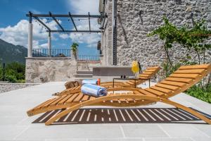a pair of wooden lounge chairs and a table at Villa Le Adria - Private HotTub - Free Beach Parking in Kozica