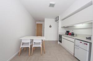 cocina con mesa blanca y electrodomésticos blancos en Libertador Complete Suite en Buenos Aires