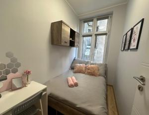 Dormitorio pequeño con 1 cama y 2 zapatillas rosas en MMRent Rose Room en Gdansk