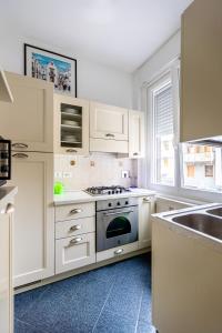 een witte keuken met een fornuis en een wastafel bij Severo Cento in Trieste