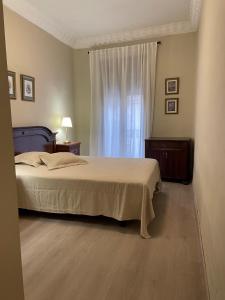 1 dormitorio con cama y ventana en La Casa Alandí con garaje privado, en Sagunto