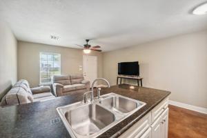 a kitchen with a sink and a living room at Lovely Lake Charles Duplex in Central Location! in Lake Charles
