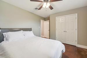 a bedroom with a white bed and a ceiling fan at Lovely Lake Charles Duplex in Central Location! in Lake Charles