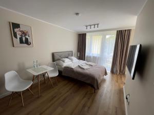 a bedroom with a bed and a table and chairs at Apartament Radiowa Premium in Olsztyn