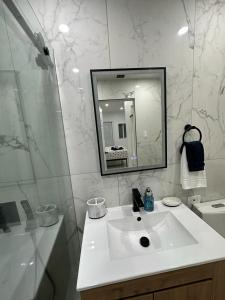 a white bathroom with a sink and a mirror at Casa West Miami in Miami