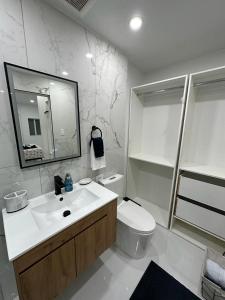 a bathroom with a sink and a toilet and a mirror at Casa West Miami in Miami