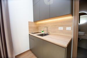 una cucina con lavandino e piano di lavoro in legno di Apartments Sirena - Modern stay with free parking a Budua Altre 37 foto