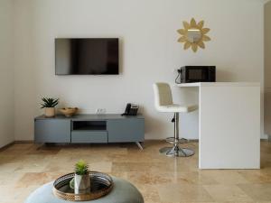 sala de estar con TV y silla en Bond Apartment - Astria Olimp, en Olimp