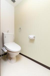 ein Bad mit einem WC und einer Rolle Toilettenpapier in der Unterkunft Healing Inn Osaka Fukushima in Osaka