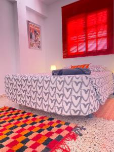 een bed in een kamer met een bank en een tapijt bij Apto a 5 min de la playa en Puertito de Güímar in Puertito de Güímar