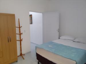 a white bedroom with a bed and a cabinet at Casa do Bruno - Apartamento terreo - 1 - Terra - Quarto e sala com cozinha americana na praia do preá-CE in Prea