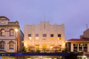a white building with a balcony in a city at Alabama Hotel Hobart in Hobart