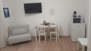 a kitchen with a table and a chair and a microwave at Affittacamere Gori 21 in Sarzana