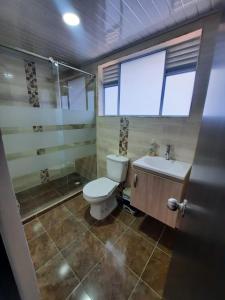 a bathroom with a toilet and a sink and a shower at CASA VACACIONAL Babilonia in Girardot
