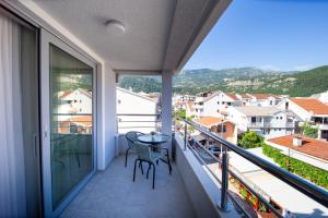 balcone con tavolo e sedie. di Apartments Sirena - Modern stay with free parking a Budua