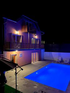 a swimming pool in front of a house at night at Villa Harmony in Bihać