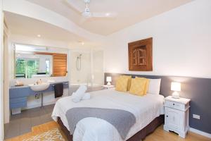 Short Stroll to White Sandy Beach في ساحة كاسوارينا: غرفة نوم بسرير وحمام مع حوض