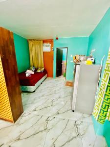 Habitación con paredes verdes y azules y nevera. en Budget-StudioRoom-Panabo-Homestay en Panabo